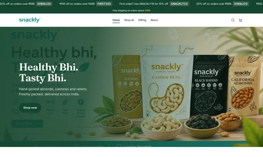 The Snackly storefront at snacklyfoods.in — promotional bar, navigation, and the hero band showing the client's own product packaging.